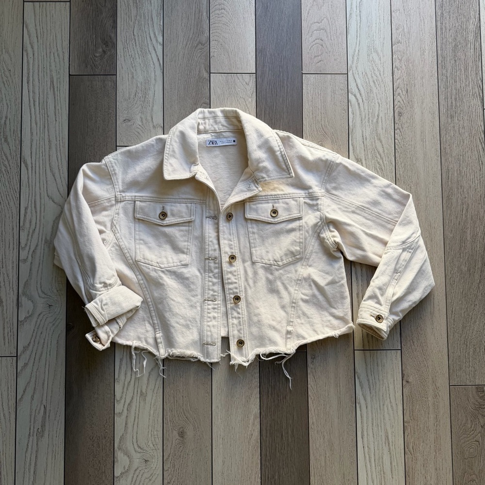 Zara cream cropped denim jacket with a distressed hem.